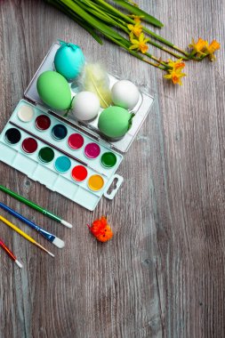 Paskalya yumurtaları, renkli boya ve fırçalar, ahşap arka planda dekoratif tavuklar. Resim yapmaya başlıyorum. Boşluğu kopyala