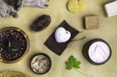 Kahve fırçası, sabun, kabuk soyma, vücut fırçası, sünger, yeşil yaprak, ağaç kabuğu, eko vücut derisi kavramı, ahşap kasede antikorlu kahve fırçası, ahşap masaj fırçaları, sabunlar, tuz, sardunya yeşili yaprak, düz uzanmış.