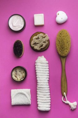 Ovalama, losyon, sabun, pamuk havlu pembe arka planda vücut bakımı için soyulan eldiven. Spa çevre dostu set seti, düz yatış