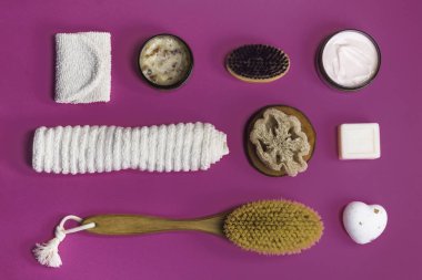 Ovalama, losyon, sabun, pamuk havlu pembe arka planda vücut bakımı için soyulan eldiven. Spa çevre dostu set seti, düz yatış