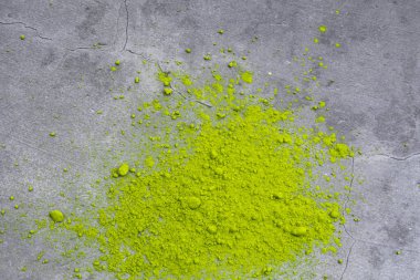 Beton zemin üzerinde Japon eşleşen yeşil çay tozu yığını. Üst manzara, yakın çekim..