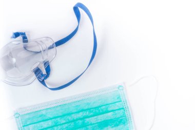 Tıbbi ultrasonik astım cihazı veya nebulizör oksijen maskesi ve beyaz arka planda hijyenik yüz maskeleri, kopyalama alanı