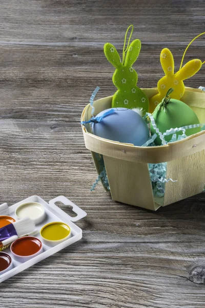 Easter basket with colorful eggs and two easter bunny, preparing for Easter concept