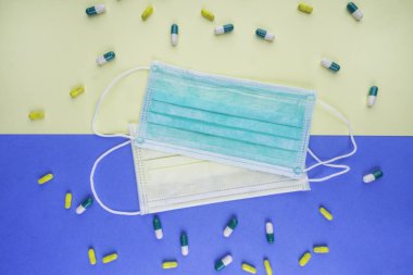 İlaçlar ve tıbbi maske. Koronavirüs salgını, karantina ve grip virüsü kavramı. Mavi arka planda koruyucu yüz maskesi, Çin 'de Coronavirus 2019-nCoV. Salgın karantina ve grip virüsü kavramı.