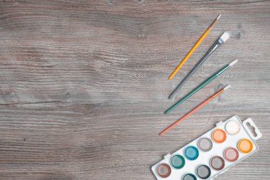 Ahşap masadaki boya ve fırçalar, sanat konsepti