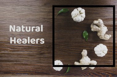 Tahta arka planda zencefilli sarımsak ve yeşil yapraklar, antiviral gıdalar, doğal şifacılar, ev yapımı ilaçlar, süper yiyecekler.