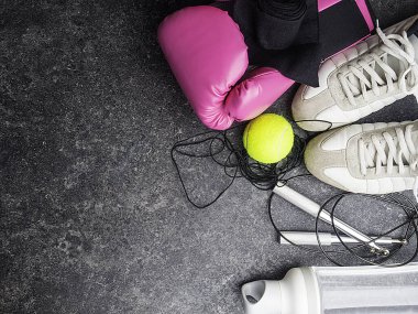 Spor ayakkabıları, deri boks eldivenleri, ip atlama, tenis topu, su şişesi, kadın boks konsepti, kopyalama alanı