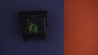 Kırmızı ve mavi arka planda siyah çöp kutusu veya geri dönüşüm kutusu, geri dönüşüm kavramı