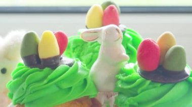 Paskalya seramik tavşanı ve tatlı renkli yumurtalı lezzetli kapkekler, tatil konsepti, seçici odaklanma