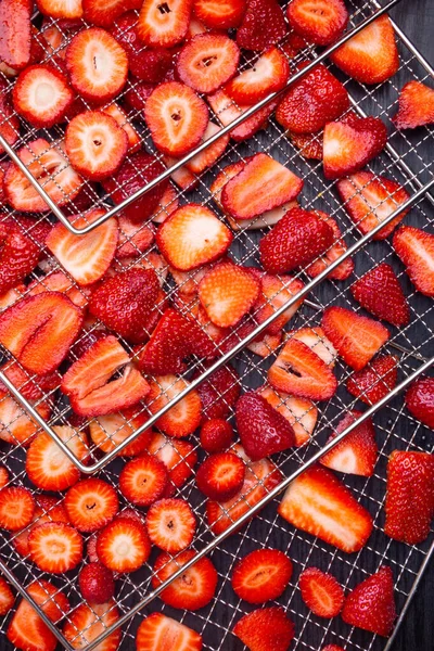 Background texture of sliced strawberries in metal trays, dehydration process, healthy snack, rich in vitamin, antioxidants, fiber