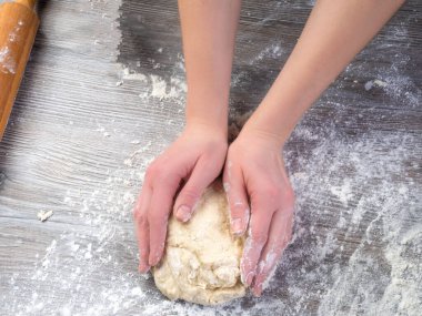Güzel kadın elleri ahşap masada hamur yoğurur, kadın elleriyle hamur yapar.