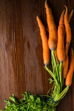 Eski ahşap zemin üzerinde taze yıkanmış havuçlar, bir sürü organik havuç, A vitamini, beta karotin dolu sebze yiyeceği.