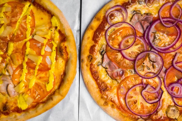 two pizzas with meat, mushroom, pineapple, tomato, onion. Traditional pastry for party, Selective focus