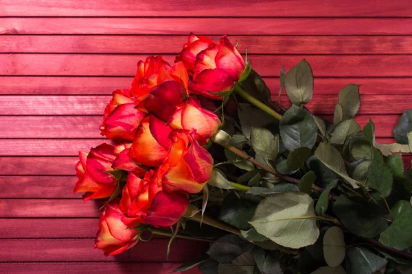 Bouquet of red roses on the wooden background