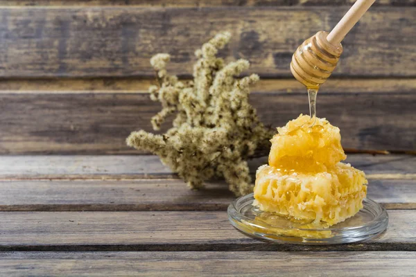 Honingraat met stroom van honing van lepel — Stockfoto