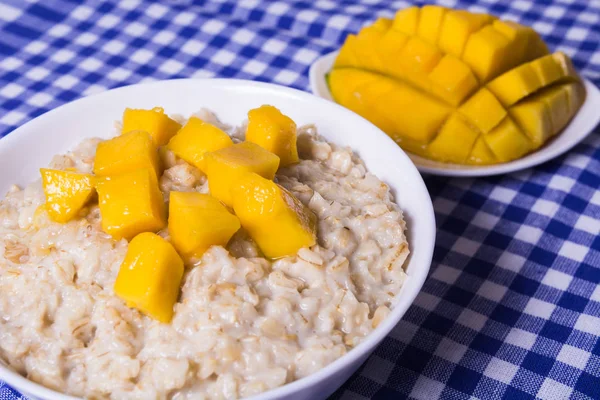 Gachas de avena con mango fresco en el tazón blanco — Foto de Stock