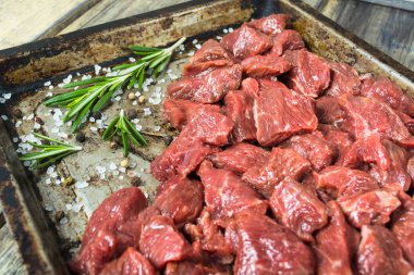 Tuz, biber ve biberiye pişirme Pan çiğ et