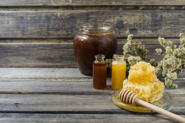 Miel de trigo sarraceno, dos tipos de miel en los frascos pequeños y panal con cuchara —  Fotos de Stock