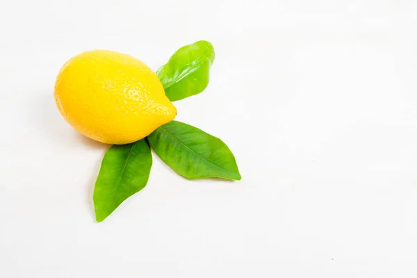 Лимон с листьями на деревянном столе — стоковое фото