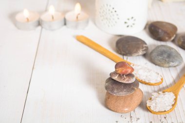 Deniz tuzu kaşık ve mumlar bir çizgi üzerinde taşlarla grup
