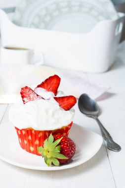 Krem şanti ve çilek ile kırmızı kağıt formunda cupcake 