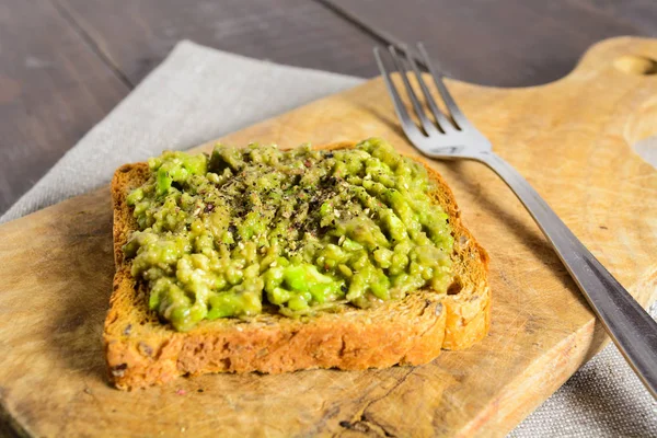 Ahşap tahta üzerinde avokado tost — Stok fotoğraf
