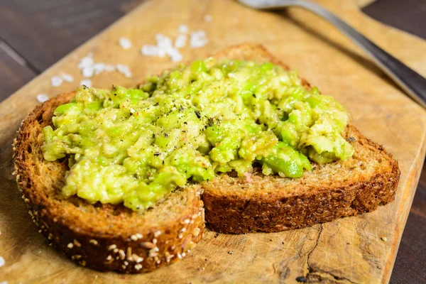 Kepekli ekmek ve biber ve tuz ile avokado tost — Stok fotoğraf