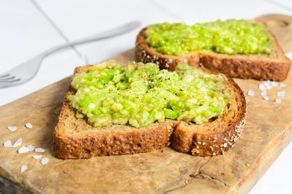 Kepekli ekmek üzerinde baharatlar ile sağlıklı avokado tost — Stok fotoğraf