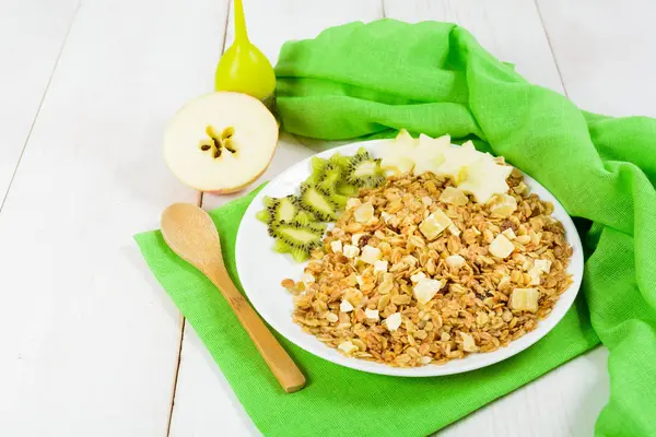 Yeşil plastik kaşık ile beyaz tabakta granola