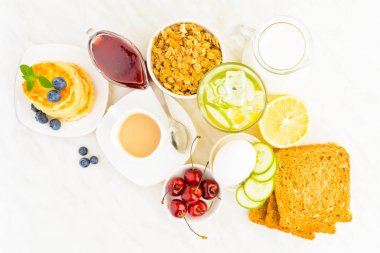 Ev yapımı kahvaltı kavramı granola, süzme peynir krep, detoks suyu, yumurta ve kahve masada