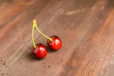 Kahverengi ahşap zemin üzerinde iki kiraz