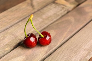 Kahverengi ahşap zemin üzerinde iki kiraz