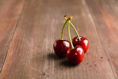 Kopya alanı ile kahverengi ahşap tabloda üç kiraz