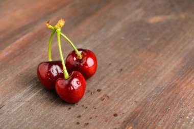 Kopya alanı ile kahverengi ahşap tabloda üç kiraz