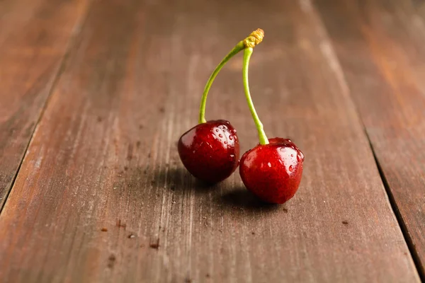 Kahverengi ahşap zemin üzerinde iki kiraz