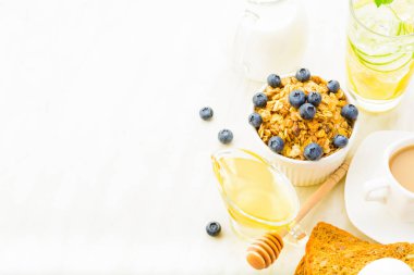 Granola, bal ve süt beyaz arka plan üzerinde ile sağlıklı kahvaltı