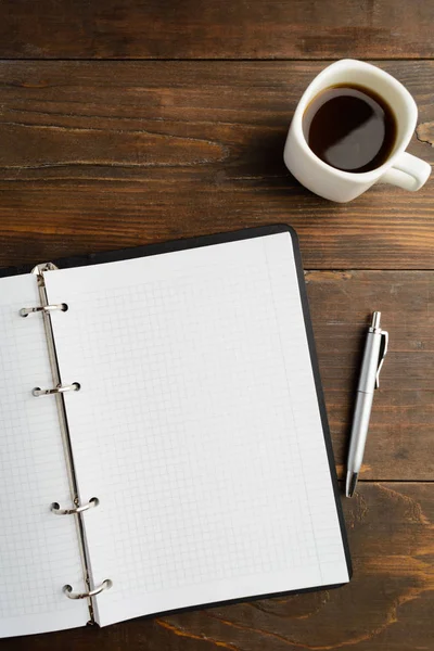 Planering koncept med öppna anteckningsboken och kaffe på träbord Stockbild