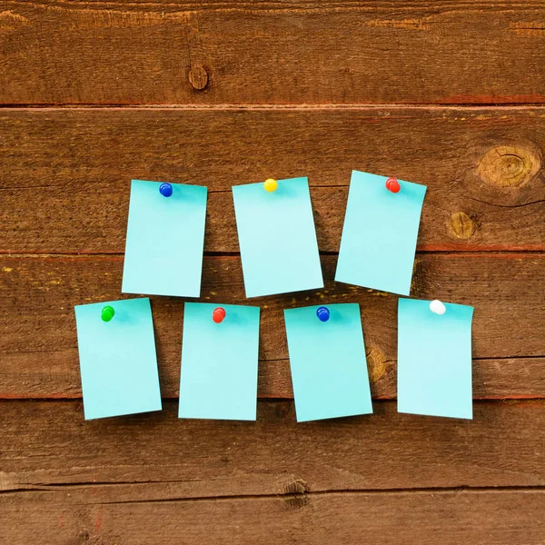 Ahşap arka plan üzerinde yedi mavi kağıt ile haftalık zamanlama