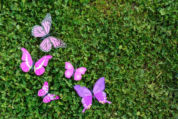 Plastikowe motyl na zielonej trawie z miejsca kopii — Zdjęcie stockowe