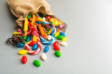 Paketi ile örümcek gri arka plan üzerinde renkli şekerler ile