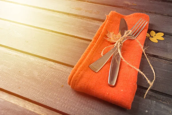 Mesa de perspectiva de otoño con tenedor, cuchillo y servilleta sobre fondo de madera — Foto de Stock