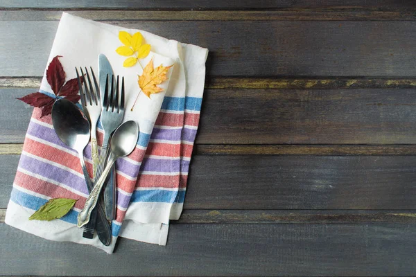 Doku üzerinde ahşap masa üzerinde yemek için hazır hizmet çatal bıçak takımı