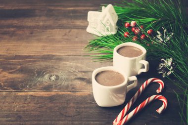 Sıcak çikolata ile lolipop, iki bardak köknar ağacı ve oyuncak ev