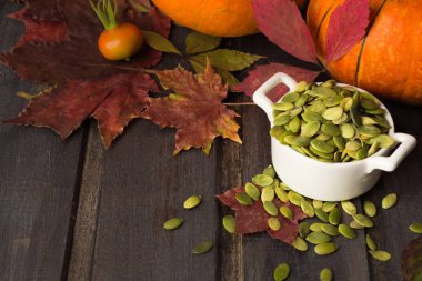 Ahşap masa üzerinde kabak çekirdeği beyaz kase