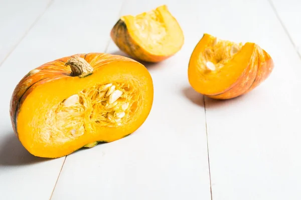 Rebanada de calabaza sobre mesa de madera blanca — Foto de Stock