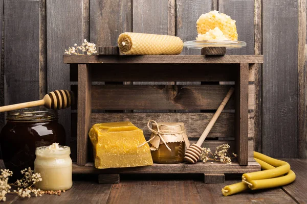 Natura morta di prodotti apicoli con cera, candele e miele — Foto Stock