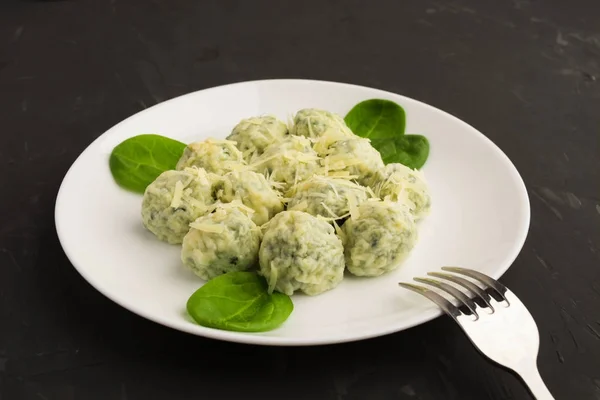 Spinacj ve peynirli gnocchi çatal ile beyaz plaka üzerinde