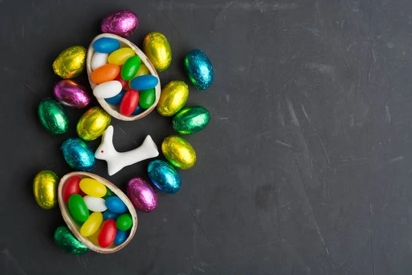 Цветные пасхальные яйца с кроликом на сером фоне с копировальным пространством — стоковое фото