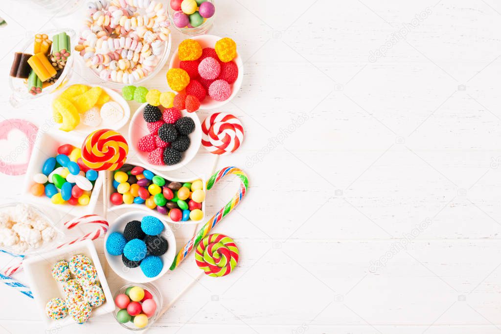 Birthday, Christmas or halloween candy bar over white wooden background. Unhealthy sweet confectionery. Copy space