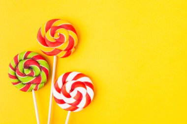 Üç renkli Noel şekeri çubukta. Doğum günü için tatlı yemek. Lolipop. Uzayı kopyala Düz yatıyordu